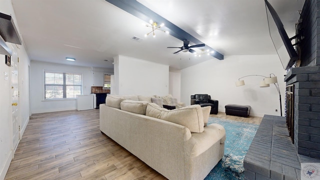 living room with a fireplace, lofted ceiling with beams, ceiling fan, and light wood-type flooring