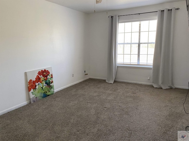 carpeted empty room featuring baseboards and ceiling fan