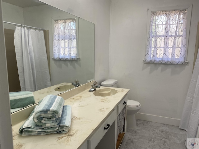 bathroom with vanity, toilet, and baseboards