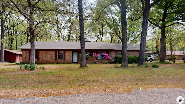 ranch-style home with brick siding and a front yard
