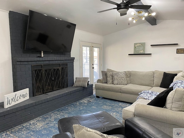 living room featuring lofted ceiling with beams, a brick fireplace, and a ceiling fan