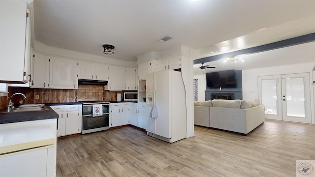 kitchen featuring white fridge with ice dispenser, double oven range, white cabinetry, and tasteful backsplash