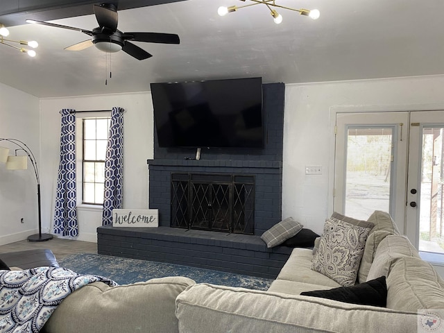 living room with a fireplace, baseboards, and ceiling fan