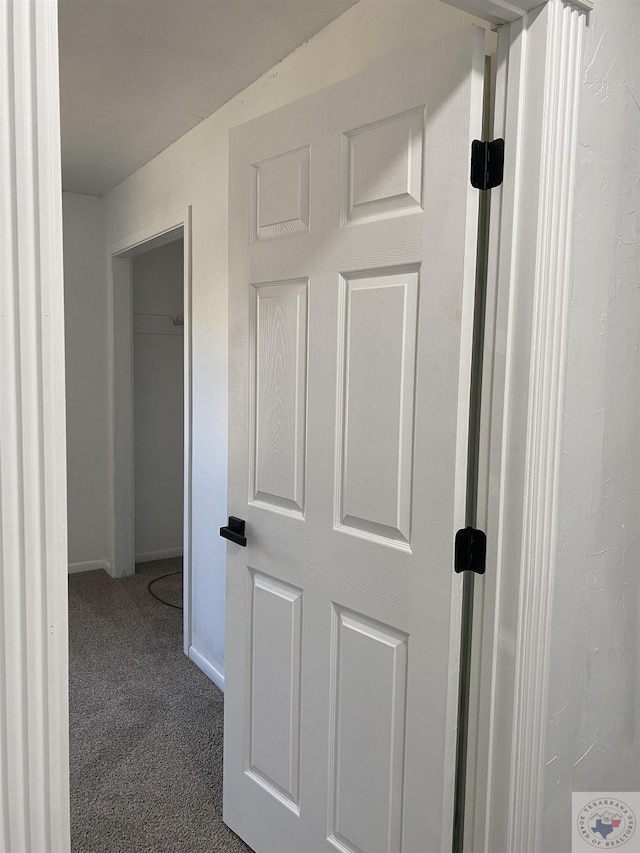 hallway with carpet and baseboards