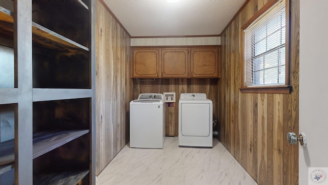 laundry room with independent washer and dryer, cabinets, a textured ceiling, ornamental molding, and wooden walls