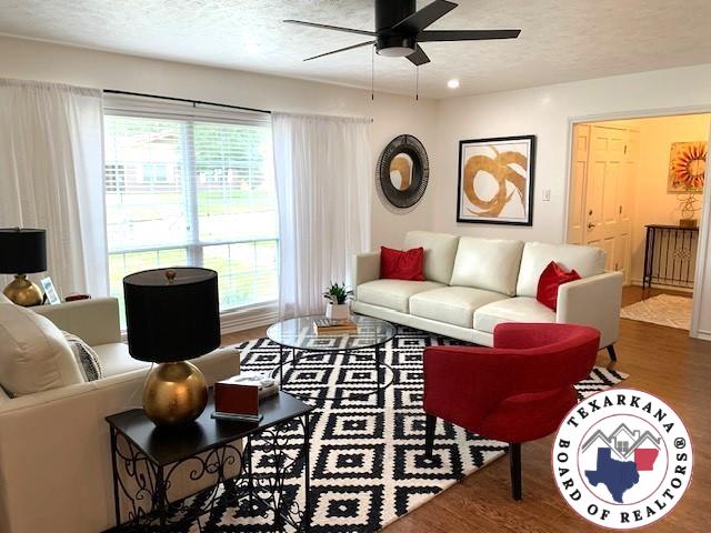 living room featuring a textured ceiling, a ceiling fan, and wood finished floors