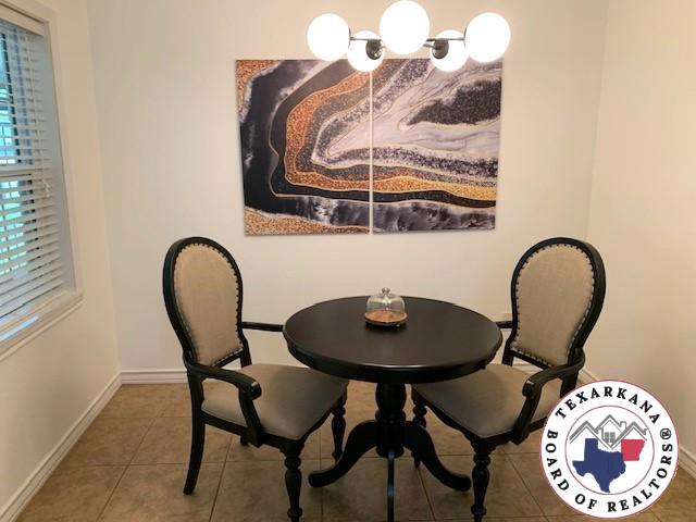 tiled dining area featuring baseboards