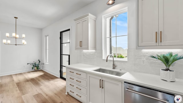 7312 Shadow Brooke, Texarkana, TX 75503 - kitchen featuring stainless steel dishwasher, a sink, decorative backsplash, light wood-type flooring, and light countertops