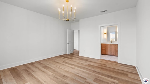 7312 Shadow Brooke, Texarkana, TX 75503 - unfurnished bedroom featuring a chandelier, light wood-style floors, ensuite bath, baseboards, and a sink