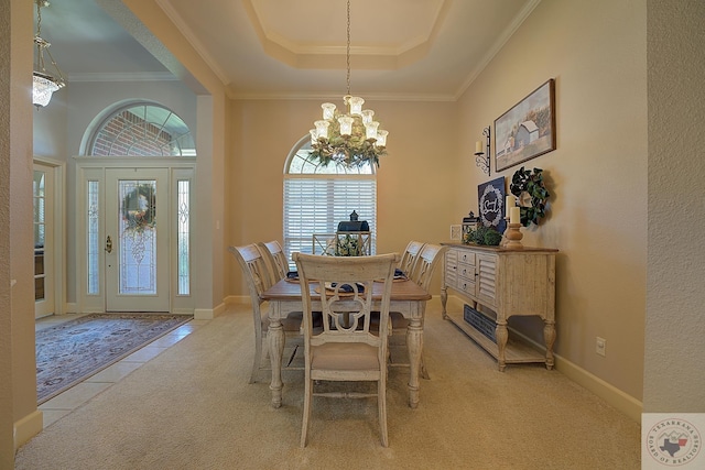 tiled dining room featuring ornamental molding, a raised ceiling, and an inviting chandelier