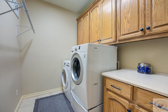 washroom featuring cabinets, washer and clothes dryer, and light tile patterned flooring