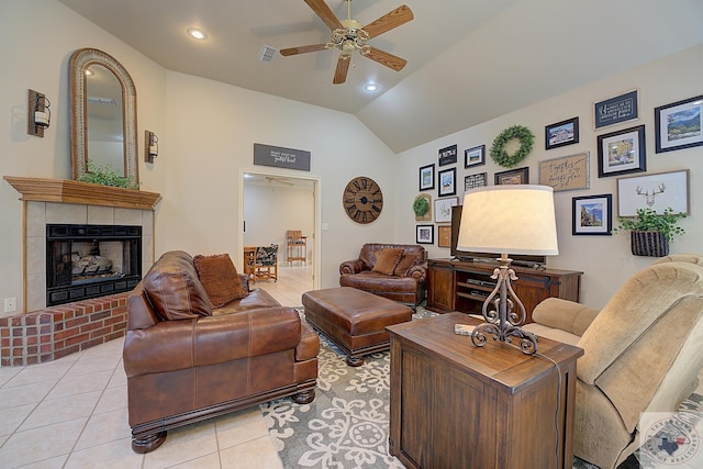 tiled living room with vaulted ceiling, ceiling fan, and a fireplace