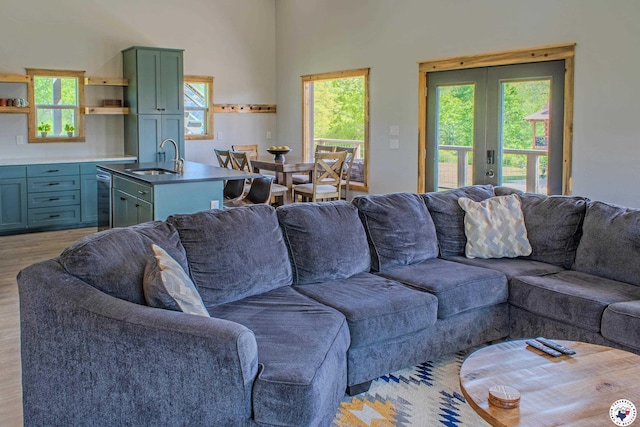 living room featuring light wood finished floors, french doors, and plenty of natural light