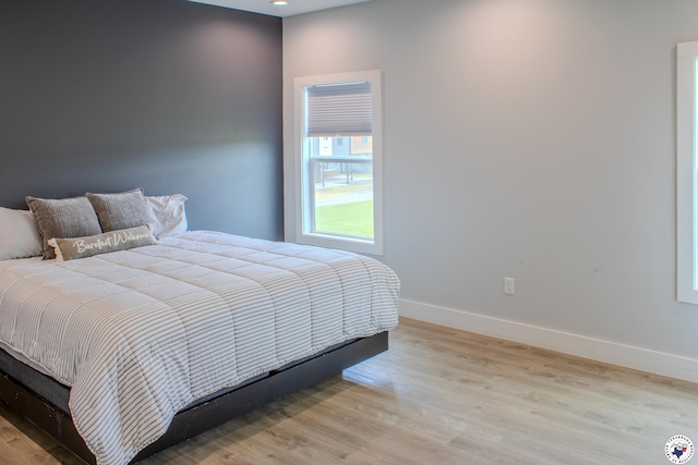 bedroom with baseboards, wood finished floors, and recessed lighting