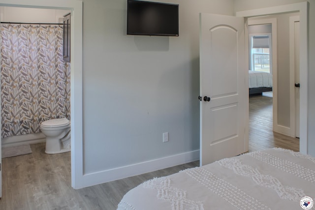 bedroom with baseboards and wood finished floors