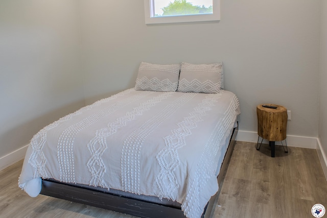 bedroom with wood finished floors and baseboards