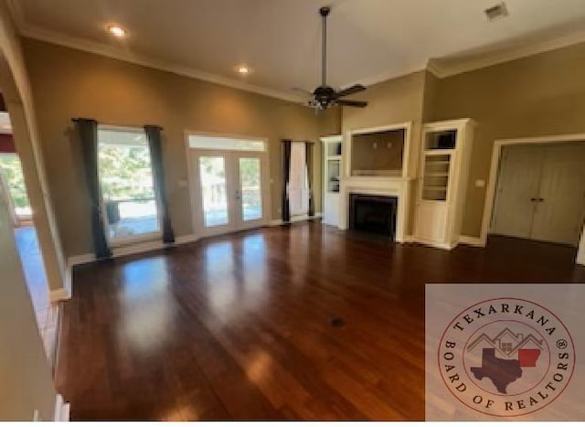 unfurnished living room with ceiling fan, dark hardwood / wood-style flooring, crown molding, and french doors