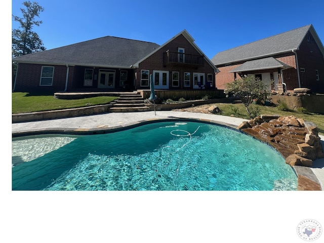 view of pool featuring french doors and a yard