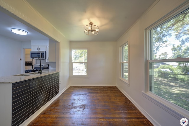 4201 Pine St, Texarkana, TX 75501 - unfurnished dining area featuring dark wood-style floors, baseboards, a sink, a chandelier, and crown molding