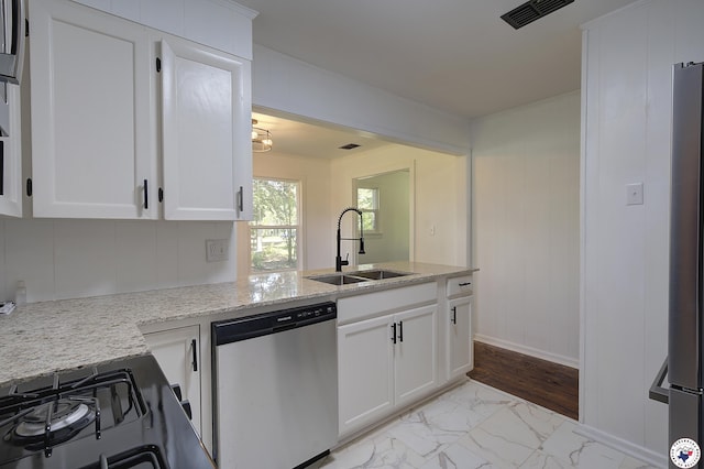 4201 Pine St, Texarkana, TX 75501 - kitchen with appliances with stainless steel finishes, a sink, light marble finish floors, white cabinetry, and light stone countertops