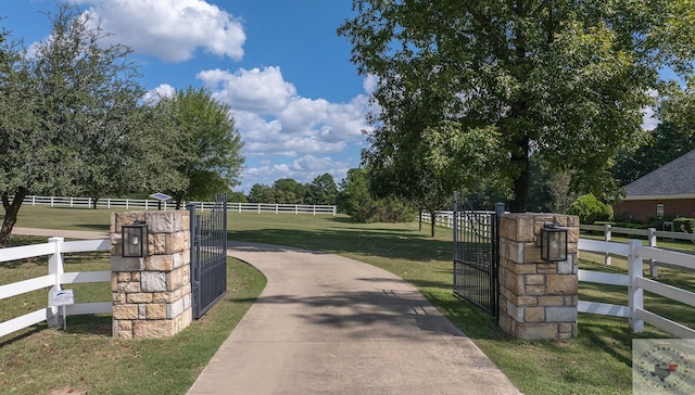 view of gate featuring a yard and a rural view