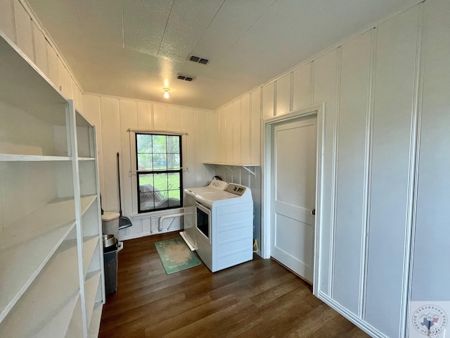 laundry room with a textured ceiling, dark hardwood / wood-style floors, and separate washer and dryer