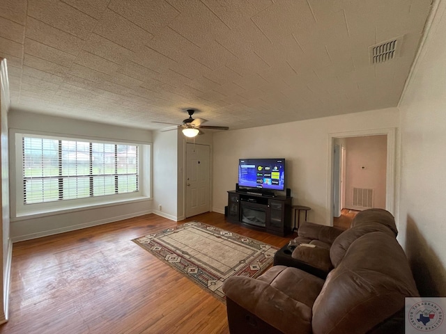 living room featuring wood-type flooring and ceiling fan