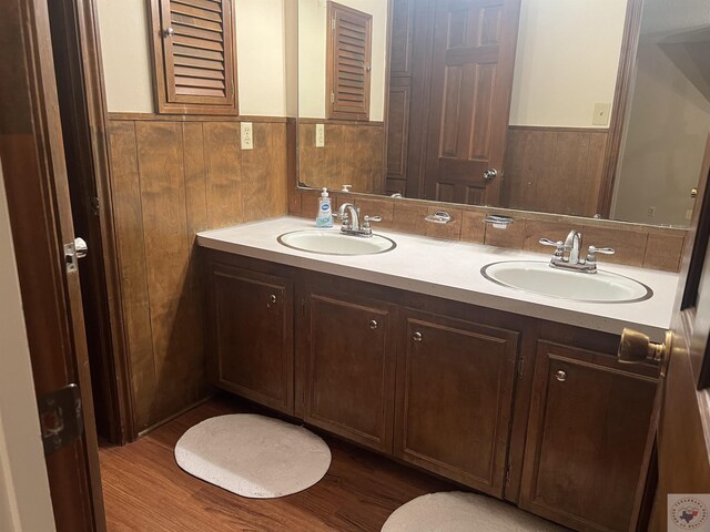 bathroom featuring hardwood / wood-style floors, vanity, and wood walls