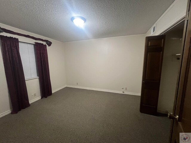 unfurnished room featuring dark colored carpet and a textured ceiling