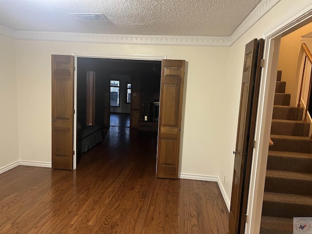 corridor with dark hardwood / wood-style floors and a textured ceiling