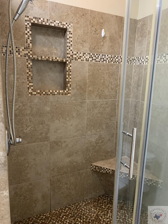 bathroom with a shower with door