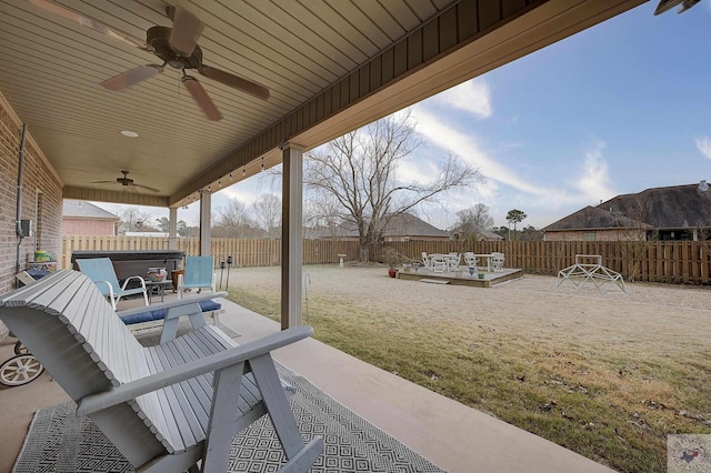 view of patio featuring ceiling fan, a deck, and a hot tub