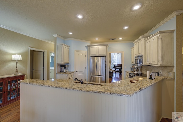 kitchen with kitchen peninsula, crown molding, and stainless steel appliances