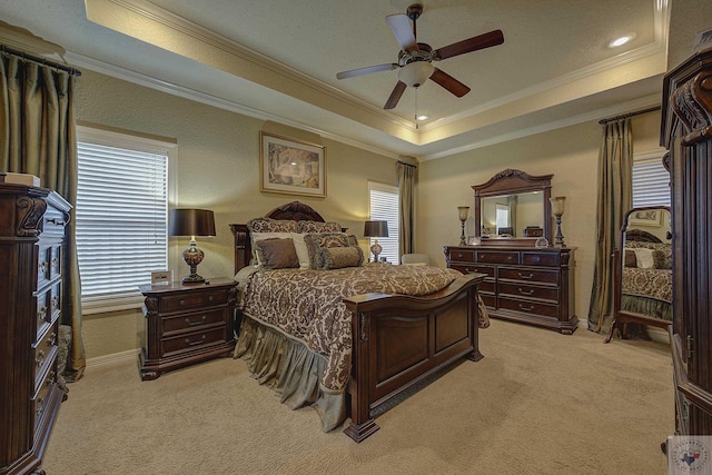 carpeted bedroom with ceiling fan, a tray ceiling, and ornamental molding