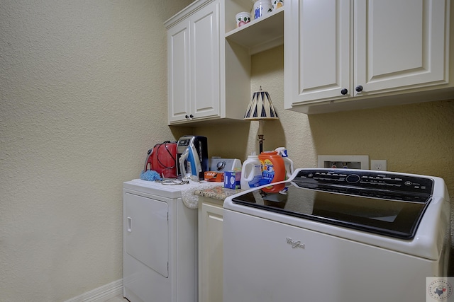 washroom with cabinets and washing machine and dryer