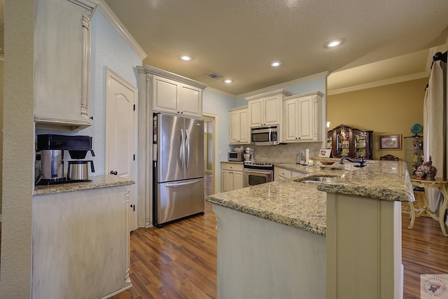 kitchen featuring light stone countertops, appliances with stainless steel finishes, light wood-type flooring, sink, and kitchen peninsula