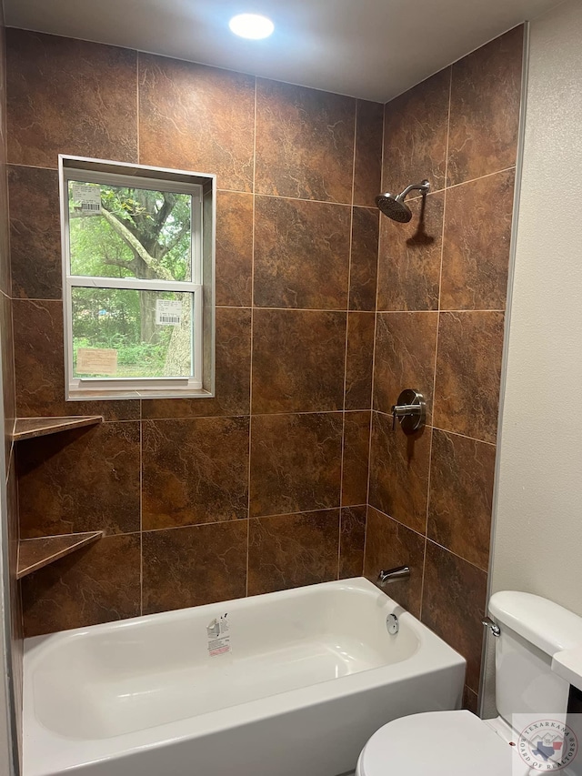 bathroom with toilet and tiled shower / bath