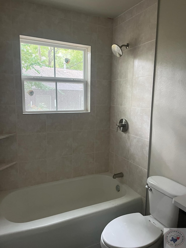 bathroom with toilet and tiled shower / bath combo