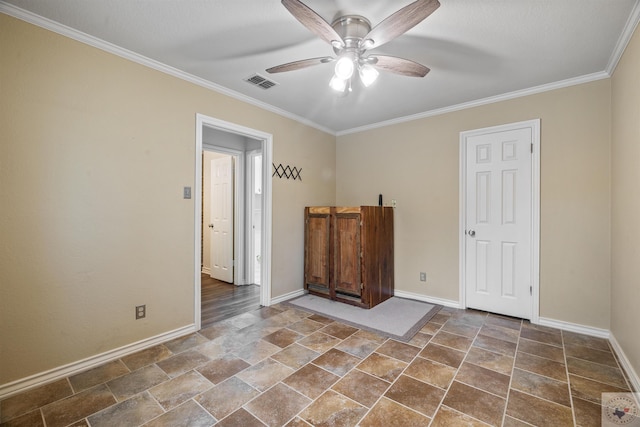 spare room with baseboards, visible vents, a ceiling fan, and ornamental molding