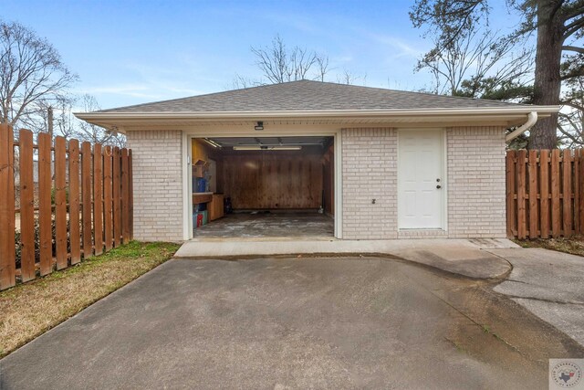 garage with driveway and fence