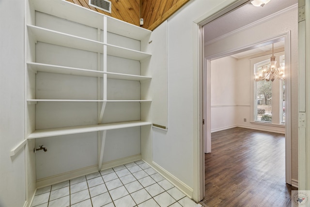 walk in closet featuring light wood finished floors, visible vents, and a chandelier