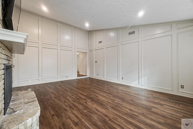 interior space featuring dark wood-style flooring, visible vents, and a decorative wall