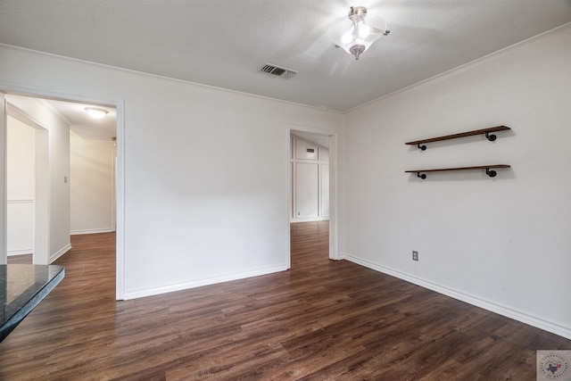 unfurnished room with dark wood finished floors, visible vents, and baseboards