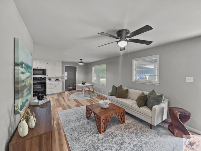 living room with light wood-type flooring and ceiling fan