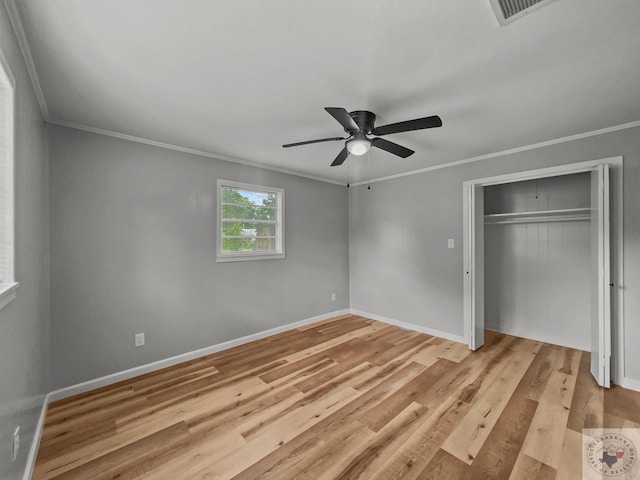 unfurnished bedroom featuring crown molding, light hardwood / wood-style floors, a closet, and ceiling fan