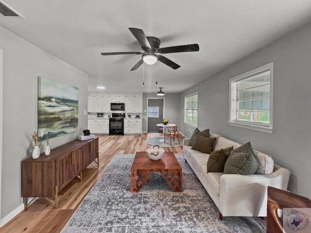 living room featuring ceiling fan and wood-type flooring