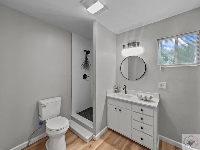 bathroom featuring hardwood / wood-style flooring, toilet, walk in shower, and vanity