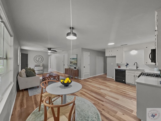 living room featuring sink, light wood-type flooring, and ceiling fan