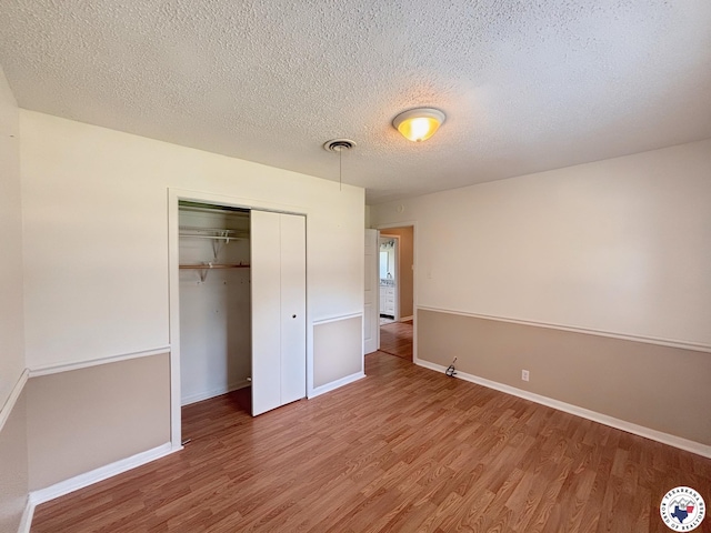 3703 Hickory St, Texarkana, AR 71854 - unfurnished bedroom with wood finished floors, a closet, and a textured ceiling