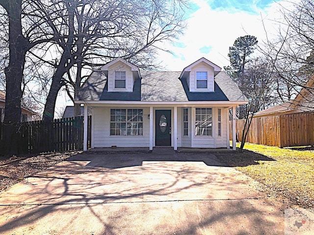 new england style home featuring driveway and fence